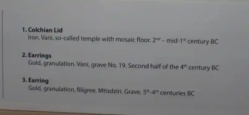 Gold earrings with a diamond pendant that looks like a 3D cross